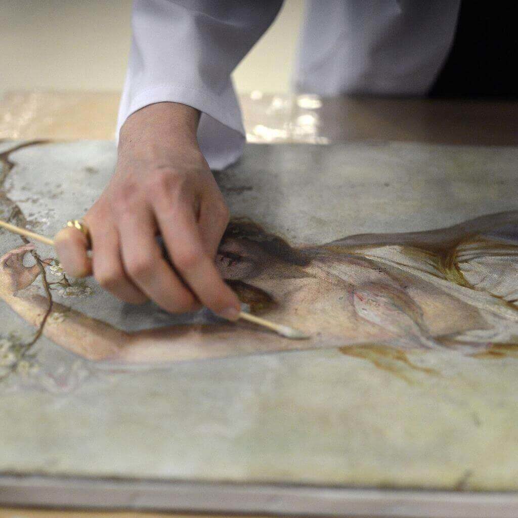 art restorer restorating a painting
