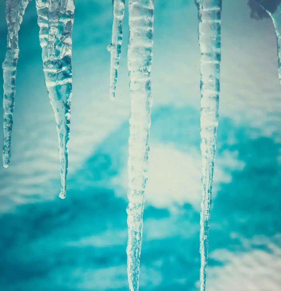 Close-up of icicles, symbolizing the risk of frozen pipes in cold climates.