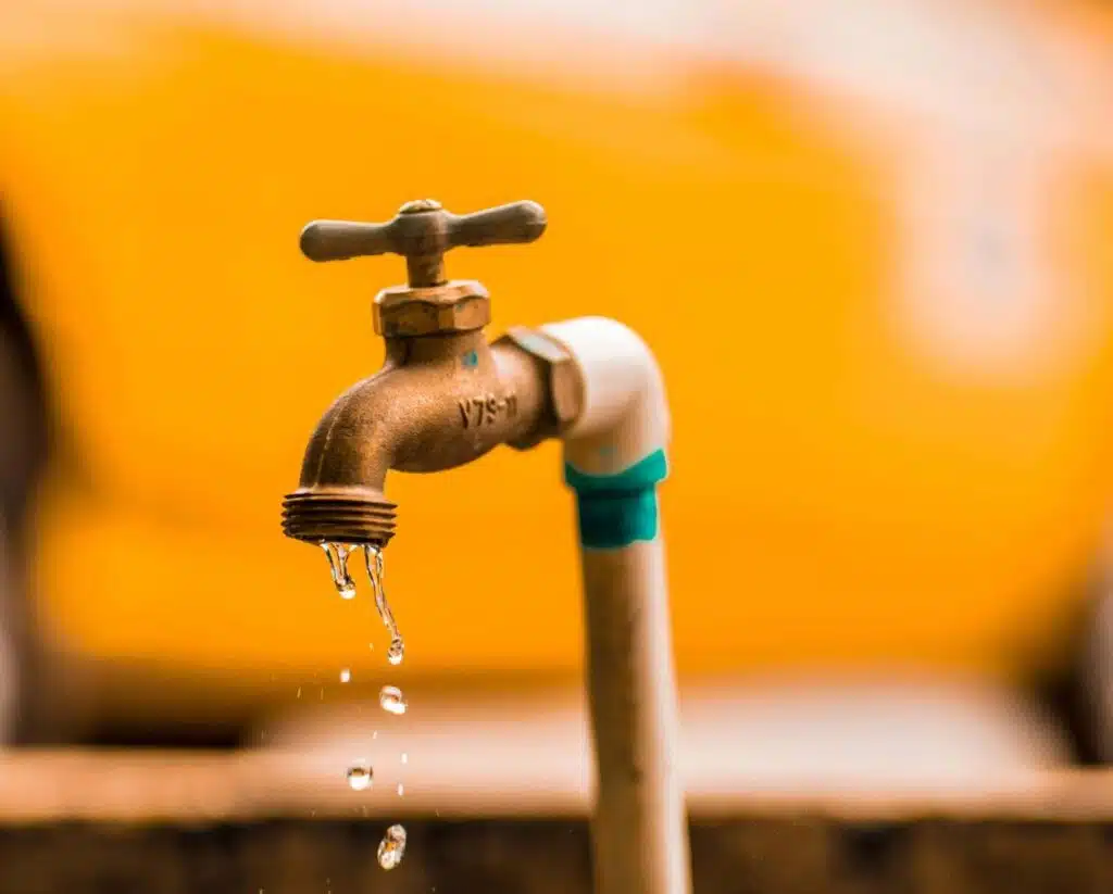 A dripping outdoor faucet showing the first step in preventing pipe freezing by keeping water moving.