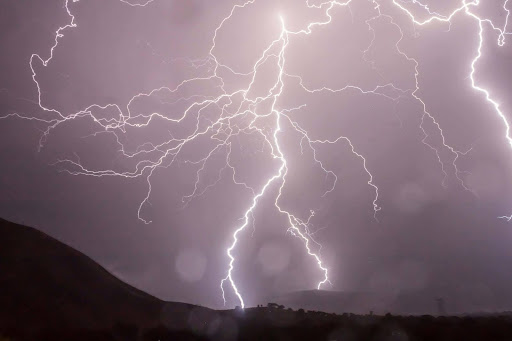 Lightning storm in a dark sky, highlighting storm damage risk.