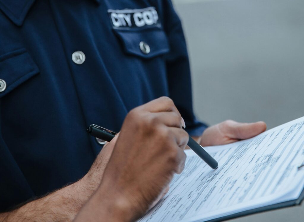 A policeman holding a report attached to a clipboard.