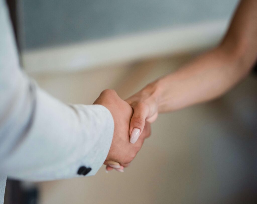 A man shaking a woman's hand professionally.