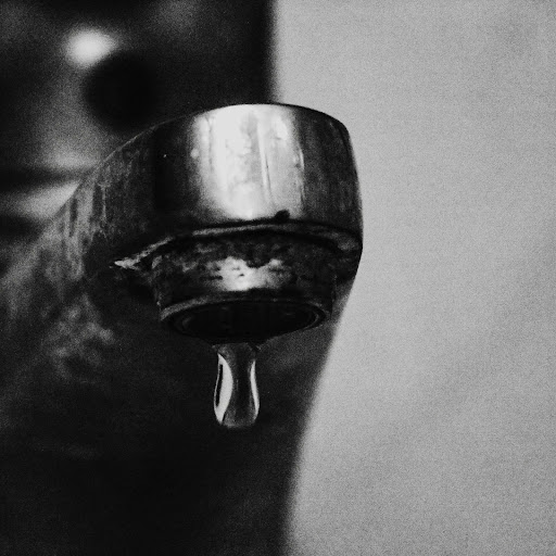 A close-up of a leaking tap dripping out water