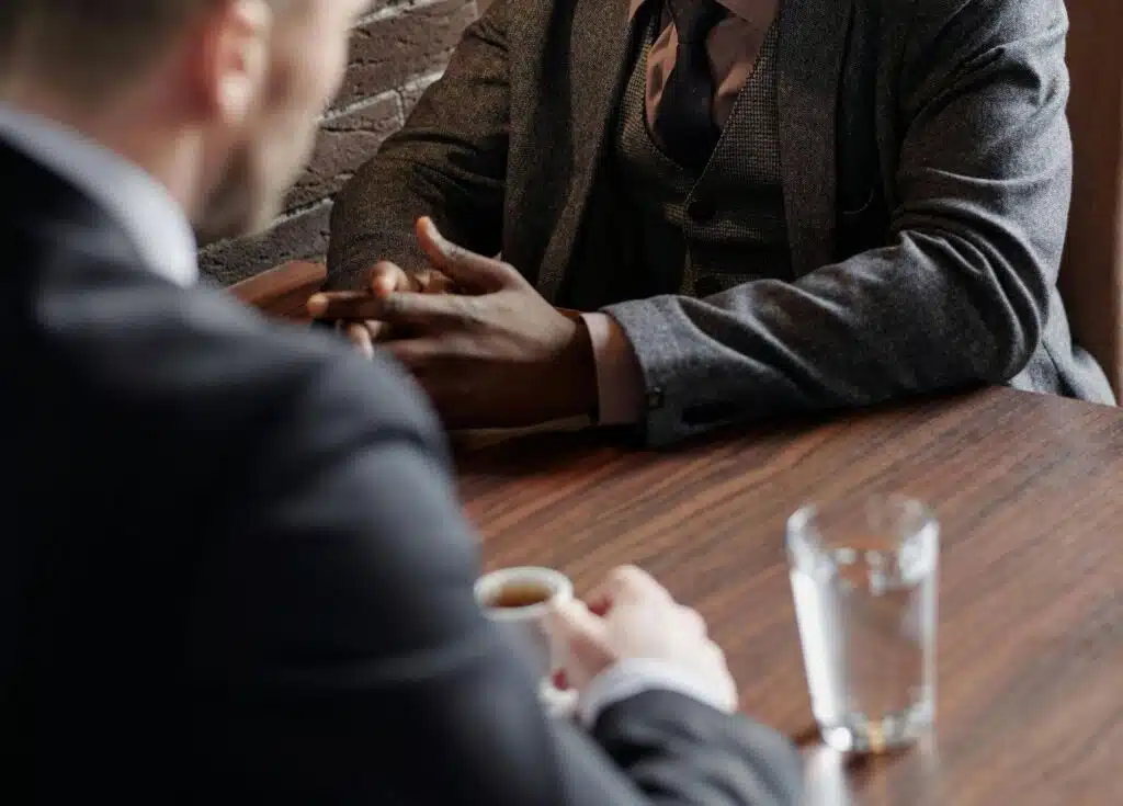 Two men in suits seated opposite one another, having a meeting.