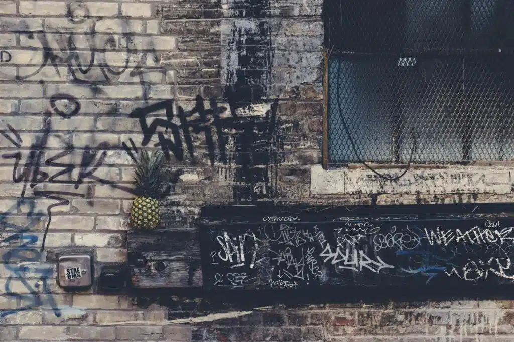 A gray brick wall covered in unreadable graffiti.