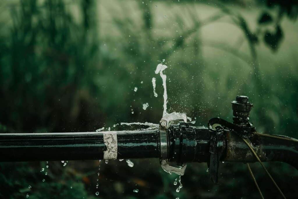 Water shooting out of burst pipe.