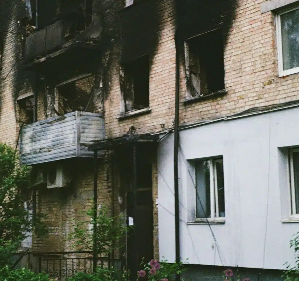 A brick building partially black with smoke from a fire.