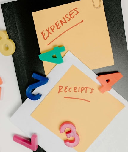 Two yellow post-it notes with the words “expenses” and “receipts” written on them.