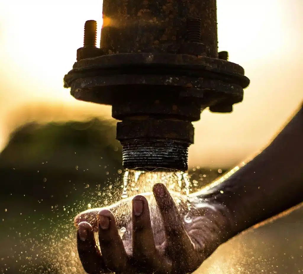 Water rushing out of a burst corroded pipe.