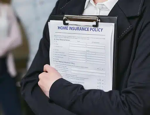 A person wrapping their arms around a home insurance policy.