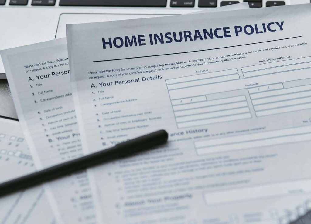 The front page of a home insurance policy with a black pen lying on it.