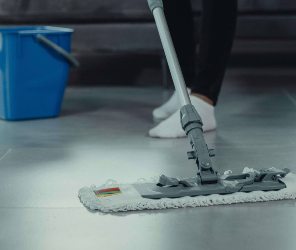 A grey flat mop on grey hardwood floors.