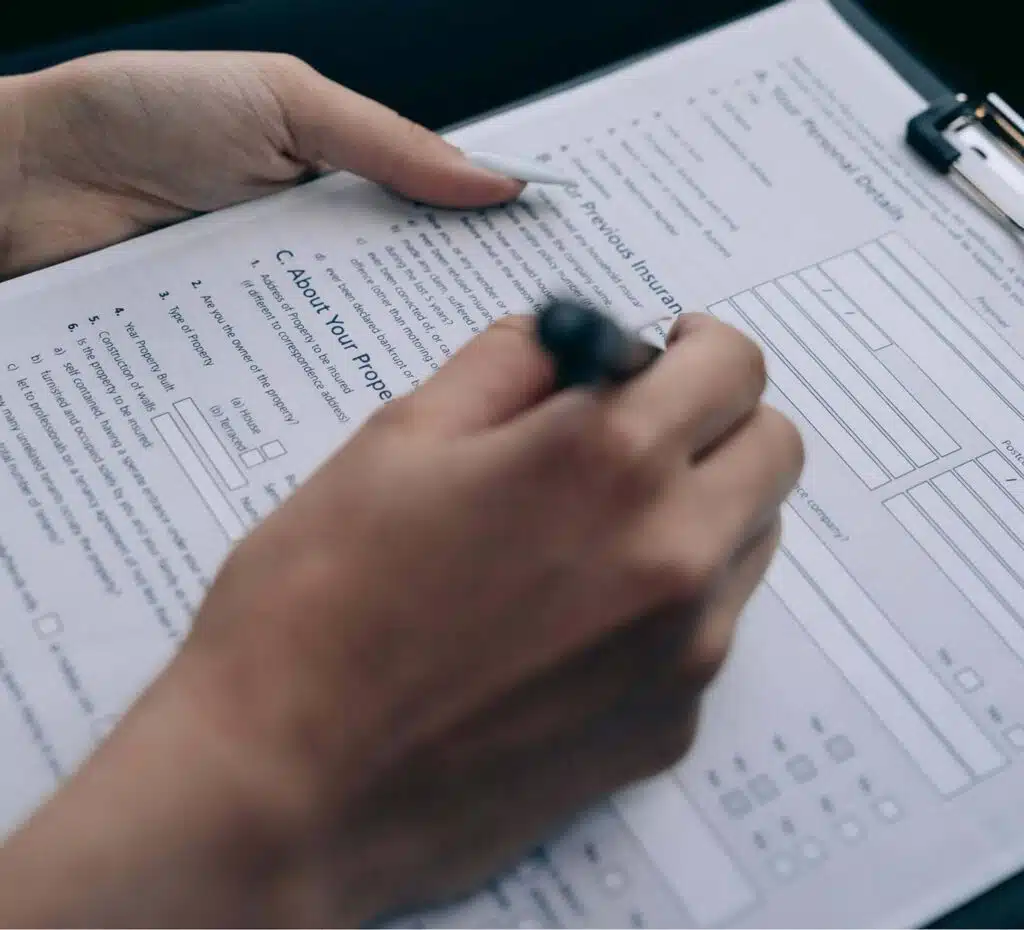 A person filling out a burst pipe insurance claim form.